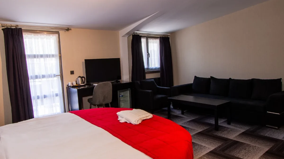 Maltepe 2000 Hotel geniş süit odada kanepeli oturma bölümü